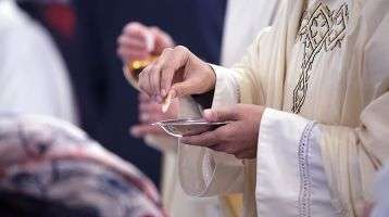 Catholic priest giving communion
