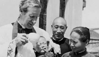 Bishop Edward Galvin baptizing a baby