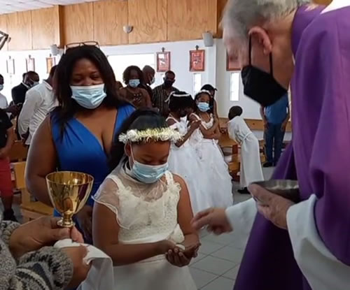 A young girl receives her First Holy Communion from Columban Fr. Mike Hoban