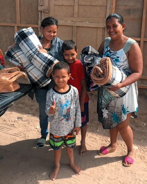 Family holding blankets they received