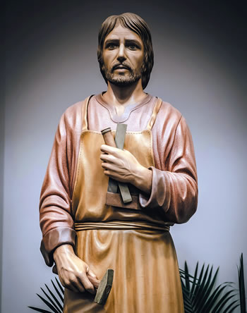 Statue of Joseph the carpenter with hammer and chisel.ker