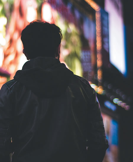 Man standing in front of neon signs
