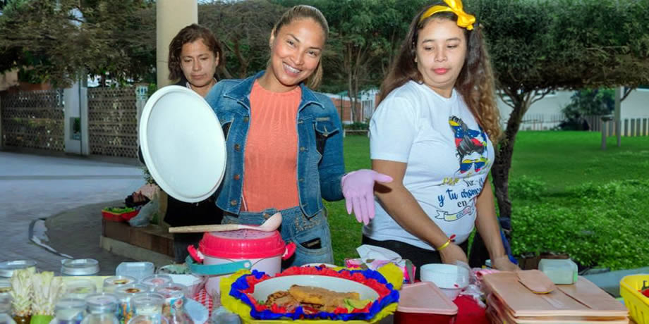Three migran women share food at a picnic
