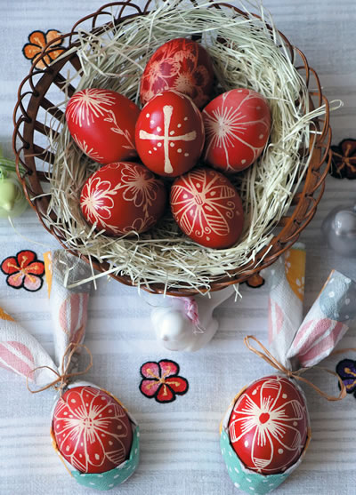 Beautifully colored Easter eggs in a basket on a table.
