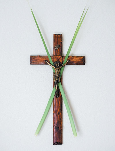 Crucifix on the wall with palms crossed