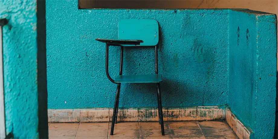 Empty school desk chair in an empty room