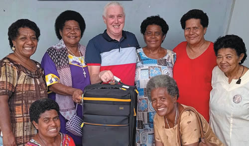 Fr. Tim with Fr. Charlie's bag and parishioners