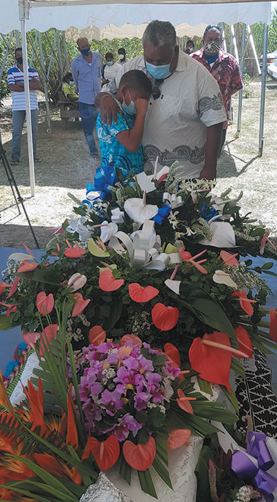 A grandson of Sonny Boy being comforted beside the casket by his uncle