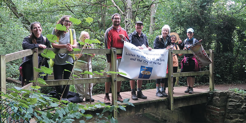 Christian walkers with a banner on a woodmen foot bridge