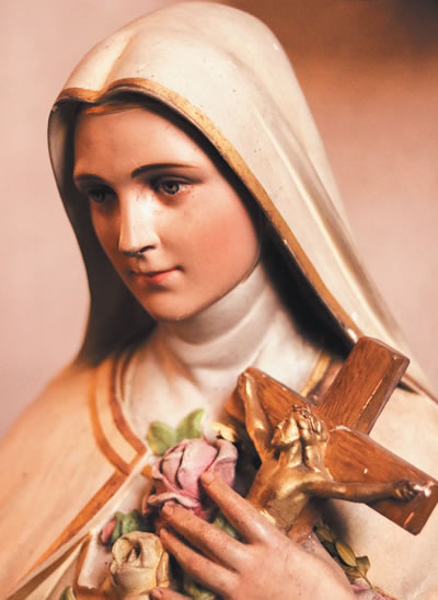 Statue of Mary holding roses and a crucifix