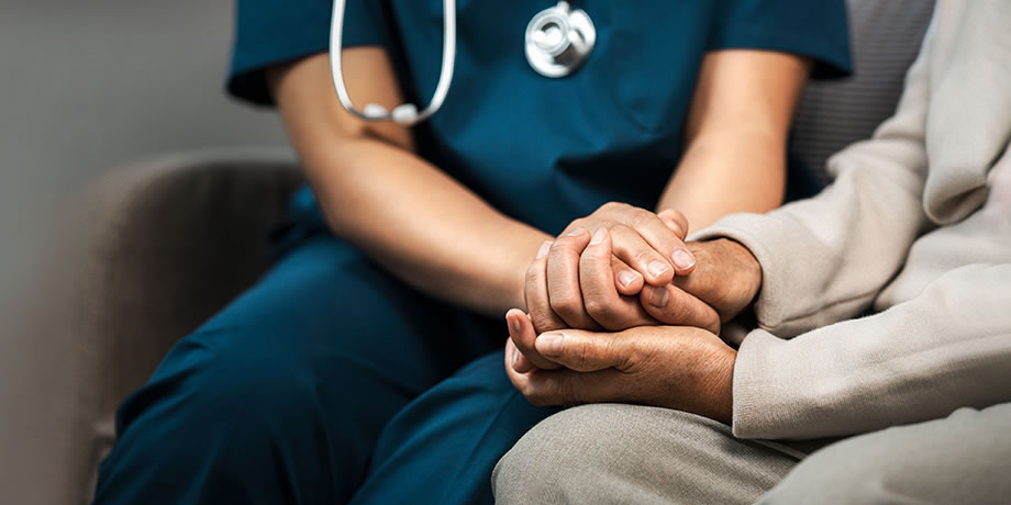 A nurse holding a patient's hand
