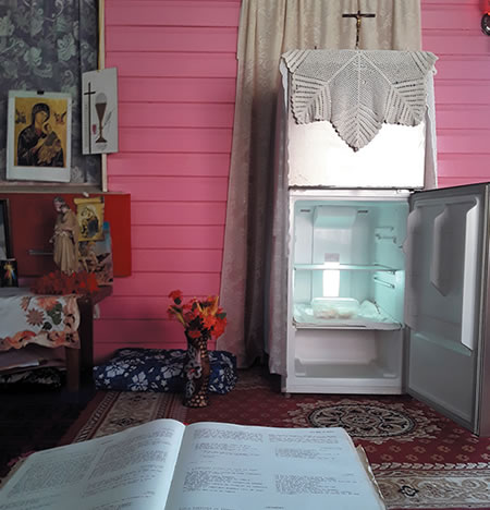 The open fridge in Votua with Eucharist stored inside; in the foreground, a Fijian lectionary.