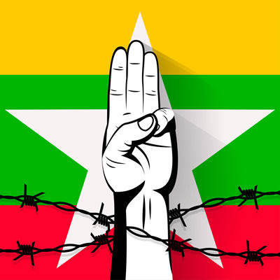 A protest sign of the three finger salute behind barbed wire on the flag of Myanmar.