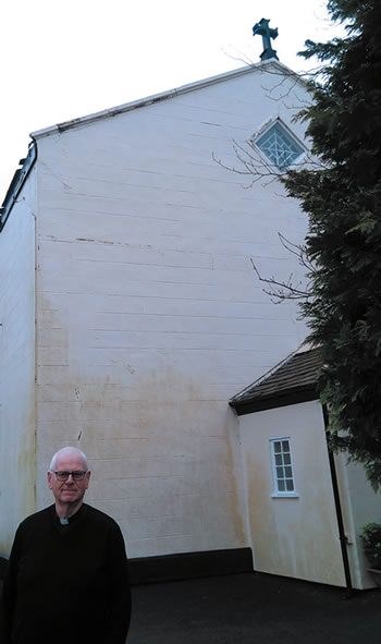 Person standing in front of the "barn" chruch