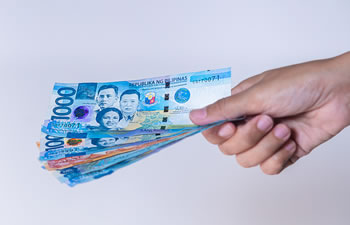 Philippine Pesos in a person's hand