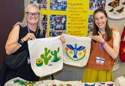 Two women holding hand-crafted bags