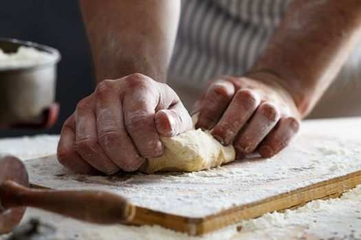 A baker's hands kneading dough.