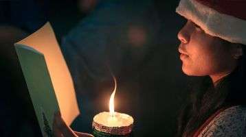 Festive Christmas singer with candle and songbook