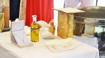 Table with holy chrism oil and other items for Catholic Confirmation