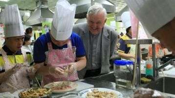 Columban Fr. Noel O'Neill looks on as food is prepared in the kitchen