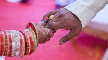 Bride and groom clasp hands during their marriage ceremony