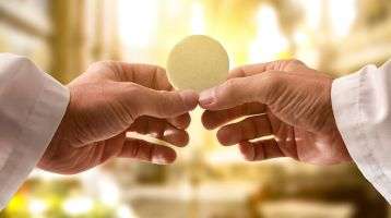 Two hands holding a communion host