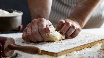 A baker's hands kneading dough.