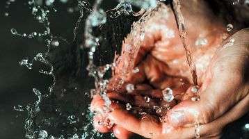 Water running into cupped hands.