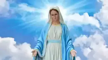 Statue of the Virgin Mary with bright blue sky and puffy clouds