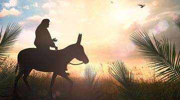 Jesus riding a donkey surrounded by palms