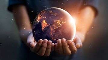 Earth at night being held in human hands