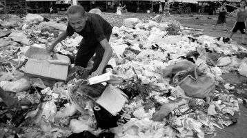 An elderly scavenger looking for usable wastes. 