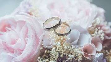 Wedding rings atop a bridal bouquet