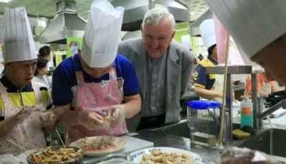 Columban Fr. Noel O'Neill looks on as food is prepared in the kitchen