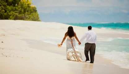 Bride and groom walking along a beach
