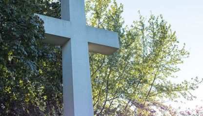 Cross with a tree-lined background