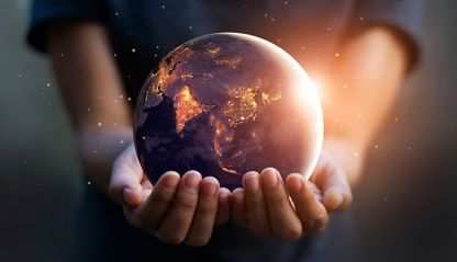 Earth at night being held in human hands