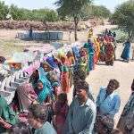 Flood victims stand in line for relief aid