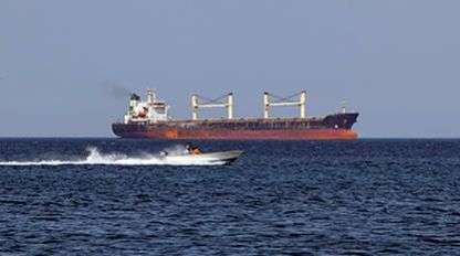 Cargo ship and speedboat in the Strait of Hormuz, Oman