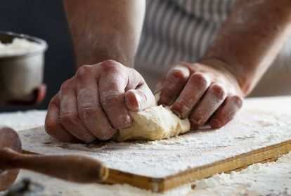 A baker's hands kneading dough.