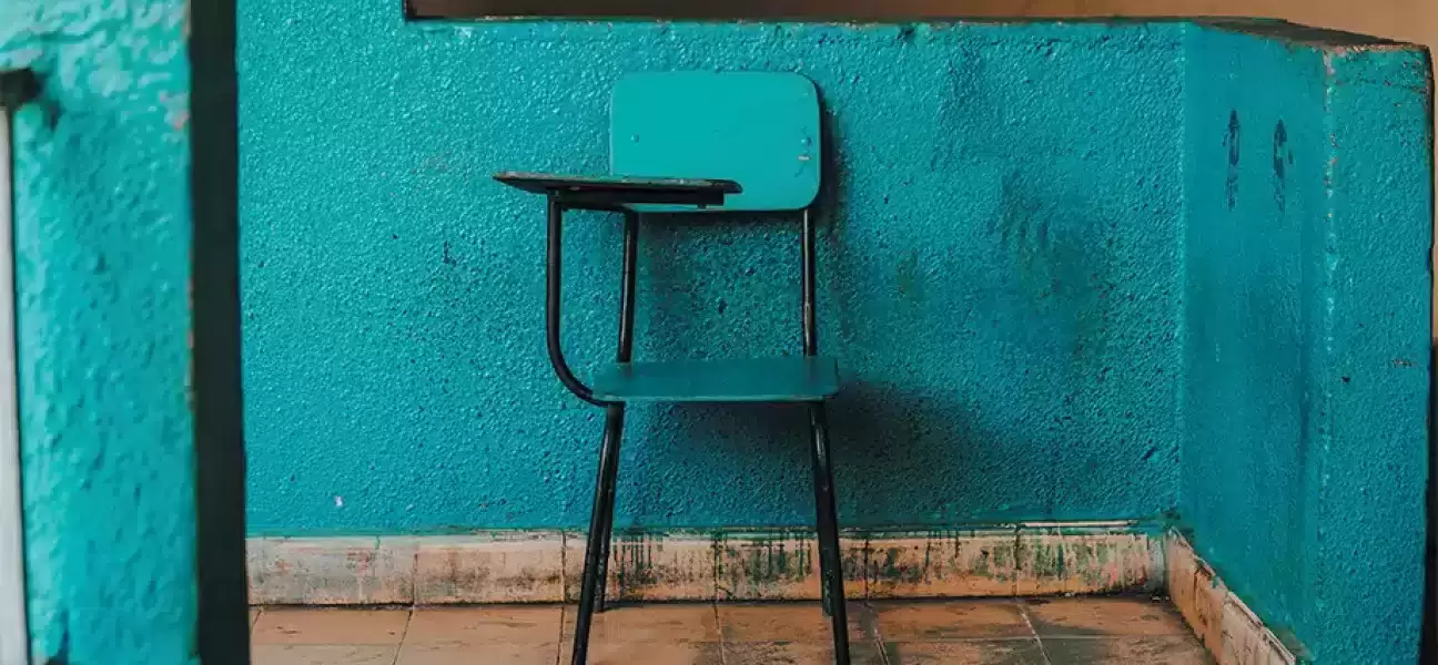 Empty school desk chair in an empty room