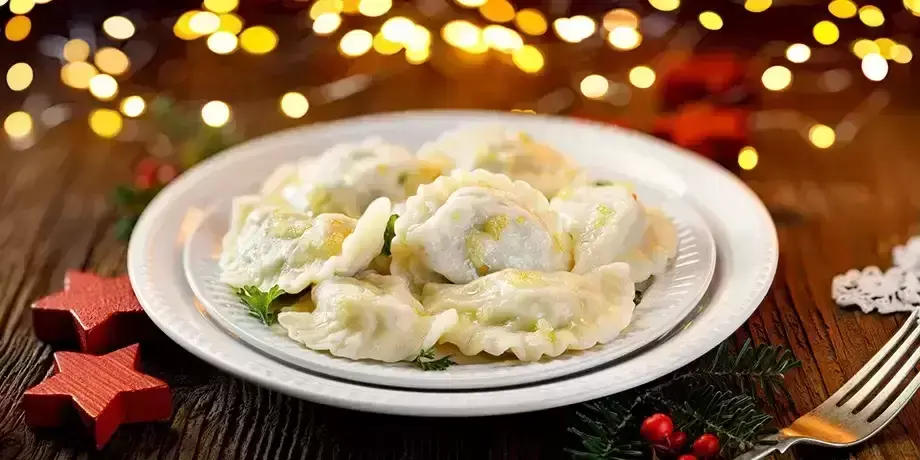 Christmas dumplings stuffed with mushroom and cabbage on a white plate.