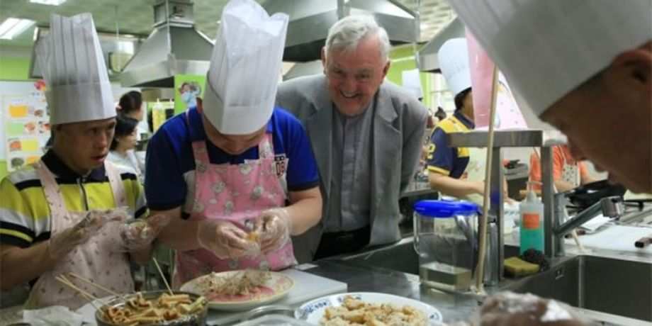 Columban Fr. Noel O'Neill looks on as food is prepared in the kitchen