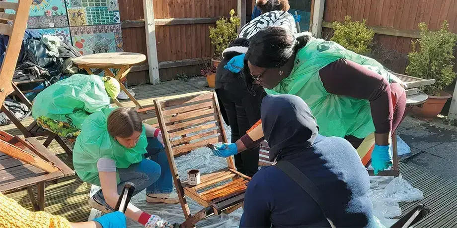 Abi (left, bending) painting garden furniture