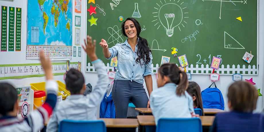 A teacher in front of her class pointing at a student