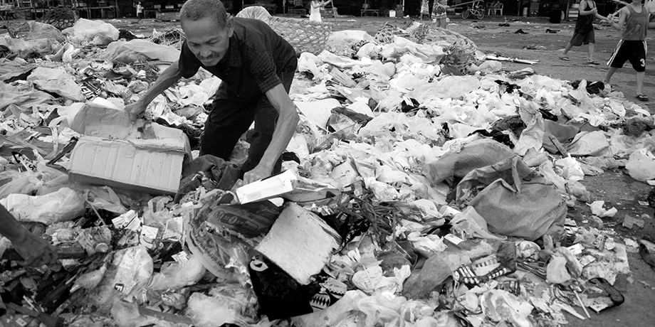 An elderly scavenger looking for usable wastes.