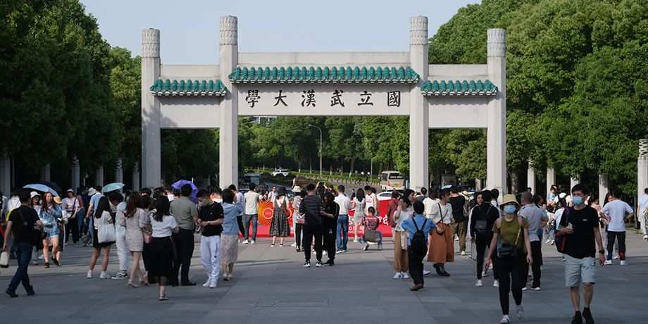 Facade of Wuhan University campus gate. With students and tourists.