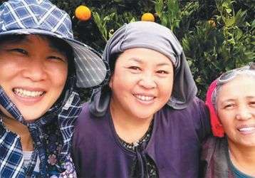 Bae (left) with village women harvesting oranges